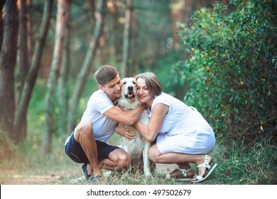 Happy Couple Of Future Parents On The Walk With Pet In The Park