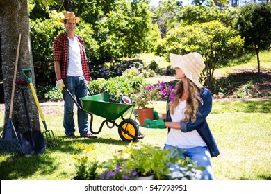 Happy Couple Gardening In The Park On A Sunny Day