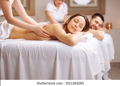 Happy Couple Getting Back Massage At Spa