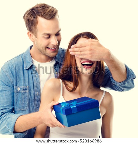 Happy couple with gift box, close to each other, with smile. Caucasian models in love, relationship, dating, flirting, lovers, romantic concept.
