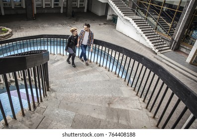 Happy Couple Going Up The Stairs In A Modern Office