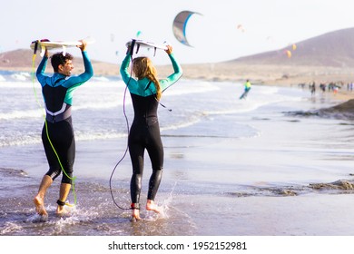 Happy Couple Going To Surf On Tropical Beach.  Friends Having Fun Doing Extreme Sport. Joyful People And Healthy Lifestyle Concept.