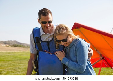 Happy Couple, Hang Glider In Background