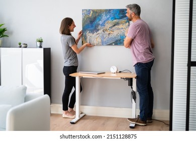 Happy Couple Hanging Painting. Wall Decoration At Home