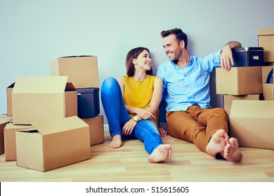Happy couple having break during moving to new house