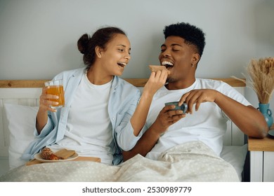 Happy couple having breakfast in bed while enjoying in morning together at home.  - Powered by Shutterstock