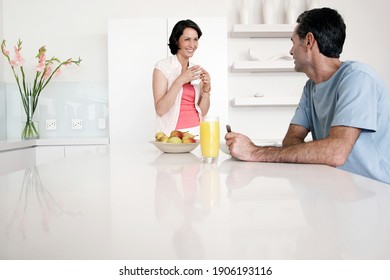 Happy couple having breakfast at kitchen bench - Powered by Shutterstock