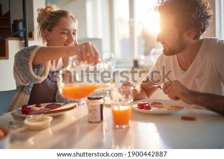 Happy couple having breakfast together in the kitchen