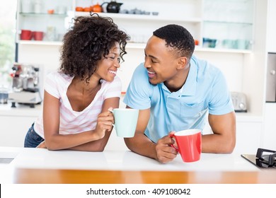 Happy Couple Having Coffee In Kitchen