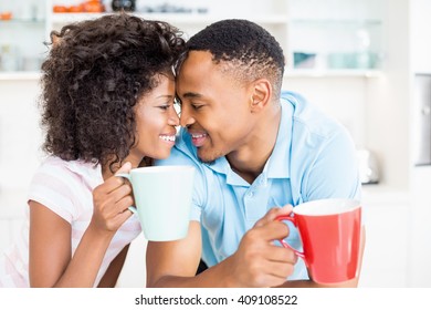 Happy Couple Having Coffee In Kitchen