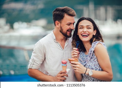 Happy couple having date and eating ice cream on vacation. Sea background. - Powered by Shutterstock