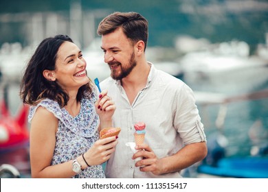 Happy couple having date and eating ice cream on vacation. Sea background. - Powered by Shutterstock