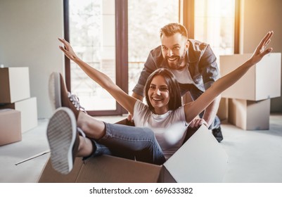 Happy couple is having fun with cardboard boxes in new house at moving day. - Shutterstock ID 669633382