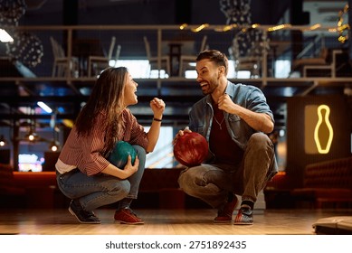 Happy couple having fun while celebrating success while bowling at the club. 