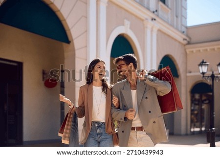 Happy couple having fun while spending a day in shopping. Copy space.