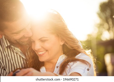 Happy couple having great time together - photographed at sunset against sun