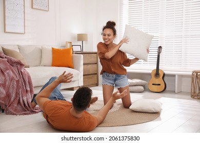 Happy Couple Having Pillow Fight In Living Room