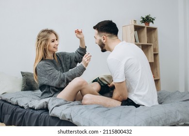 Happy Couple Having Pillow Fight In Hotel Room