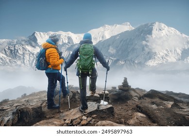 Happy couple hikers with backpacks in mountains talking and enjoying scenic on view of mountains during a hike in Himalayas, Nepal.
Beautiful inspirational landscape, trekking and activity. - Powered by Shutterstock