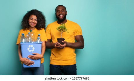 Glückliches Paar hält einen Plastikbehälter und einen kleinen Baum über einer hellblauen Farbe. Konzept der Aufforstung, Ökologie, Erhaltung, Recycling und Nachhaltigkeit