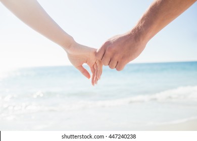 happy couple holding hands on the beach