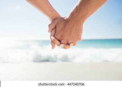 happy couple holding hands on the beach