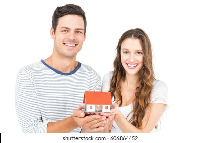 Happy Couple Holding Miniature House On White Background