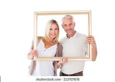 Happy couple holding a picture frame on white background - Powered by Shutterstock