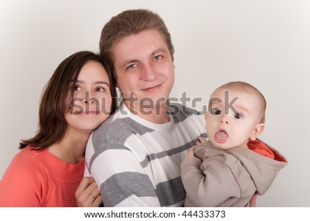Happy couple holding a surprised baby