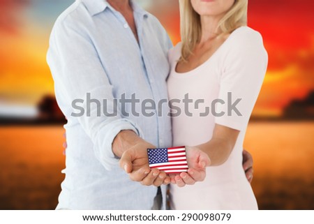 Happy couple holding their hands out against countryside scene