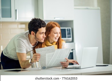 Happy Couple At Home Paying Bills With Laptop And Looking Screen