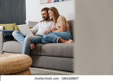 Happy Couple At Home Relaxing With Laptop Computer