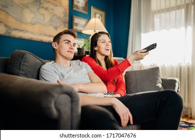 Happy Couple At Home Watching TV Together.Remote Control Fight.Watching Favorite Show/film.Fun Comedy Movie.Binge Watching Television.Relationship Home Quarantine Lockdown Time.Streaming Service