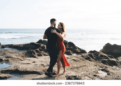 Happy couple hugging and dancing on rocky seashore - Powered by Shutterstock
