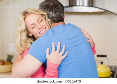 Happy Couple Hugging In The Kitchen