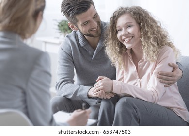 Happy Couple Hugging And Smiling During Therapy Session