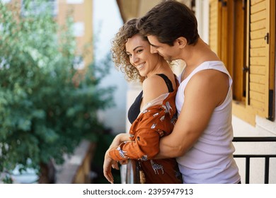 Happy couple hugging while spending time together in balcony at home - Powered by Shutterstock