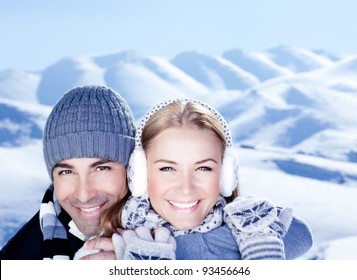 Happy couple hugs, holding hands, close up face portrait, outdoor at winter snowy mountains, people over natural blue wintertime landscape background, Christmas vacation holidays, love concept - Powered by Shutterstock