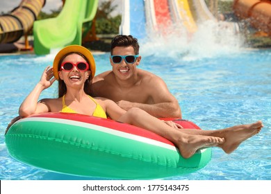 Happy Couple With Inflatable Ring At Water Park. Summer Vacation