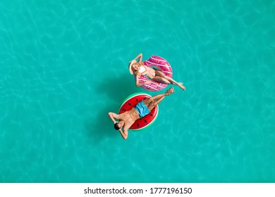 Happy couple with inflatable rings in swimming pool, top view. Summer vacation - Powered by Shutterstock