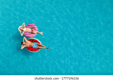 Happy couple with inflatable rings in swimming pool, top view and space for text. Summer vacation - Powered by Shutterstock