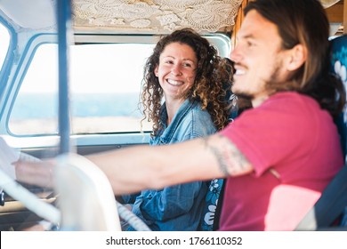 Happy couple inside minivan doing a road trip - Woman with freckles having fun on summer vacation traveling with her boyfriend - Van lifestyle, love and holiday concept - Focus on girl face - Powered by Shutterstock