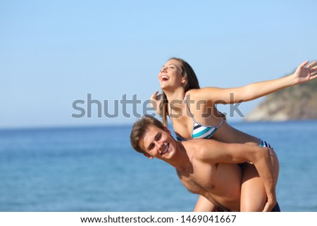 Happy couple joking celebrating summer vacation on the beach