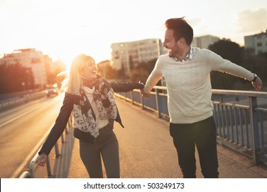 Happy Couple Jumping From Joy In Sunset