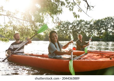 Happy couple kayaking on the river surrounded by trees, enjoying adventurous experience. Leisure, sport concept