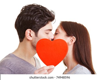 Happy Couple Kissing Behind A Red Heart