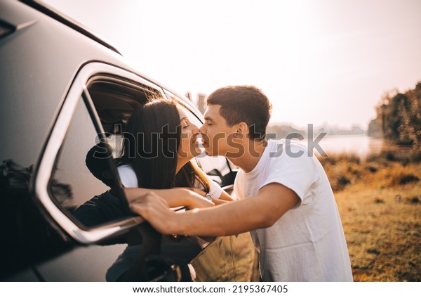 happy couple\
kissing in car traveling in\
car