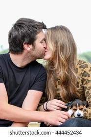 Happy Couple Kissing With Pet Dog