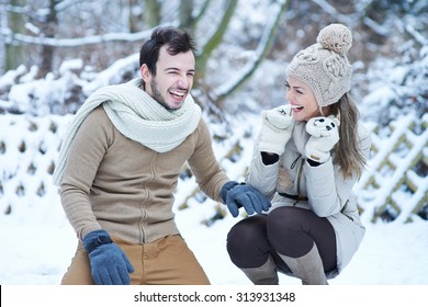 Happy Couple Laughing Together In Winter Snow Outdoors