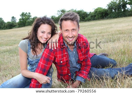 Happy couple laying down meadow